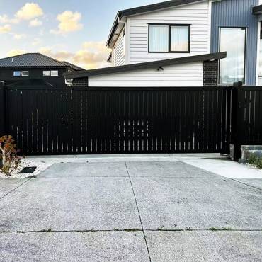 Fence NZ: A new residential sliding gate providing secure, space-saving access to an Auckland home.