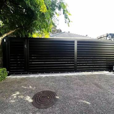 Professional louvre gates installed by Fence NZ, a sleek and functional design for an Auckland home.