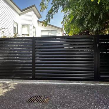 Auckland home with new louvre gates, a smart fencing solution that offers security without blocking sunlight.